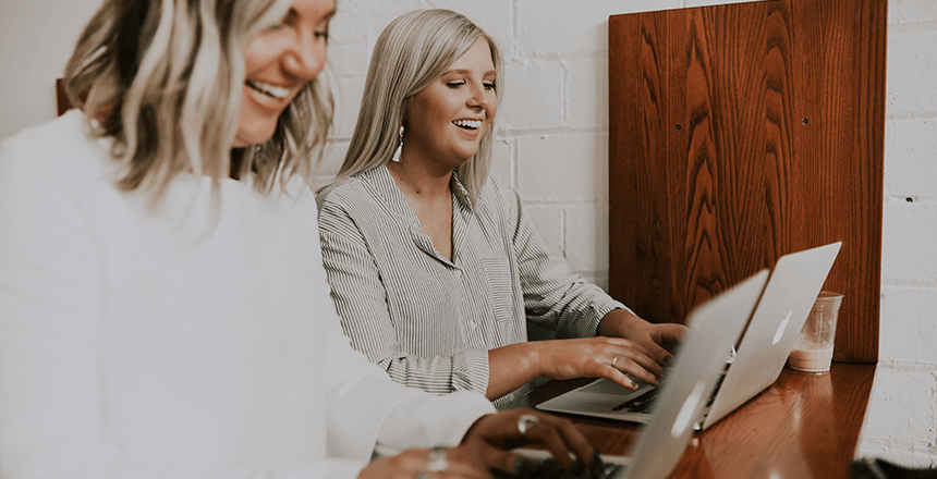 two women are working on their laptops